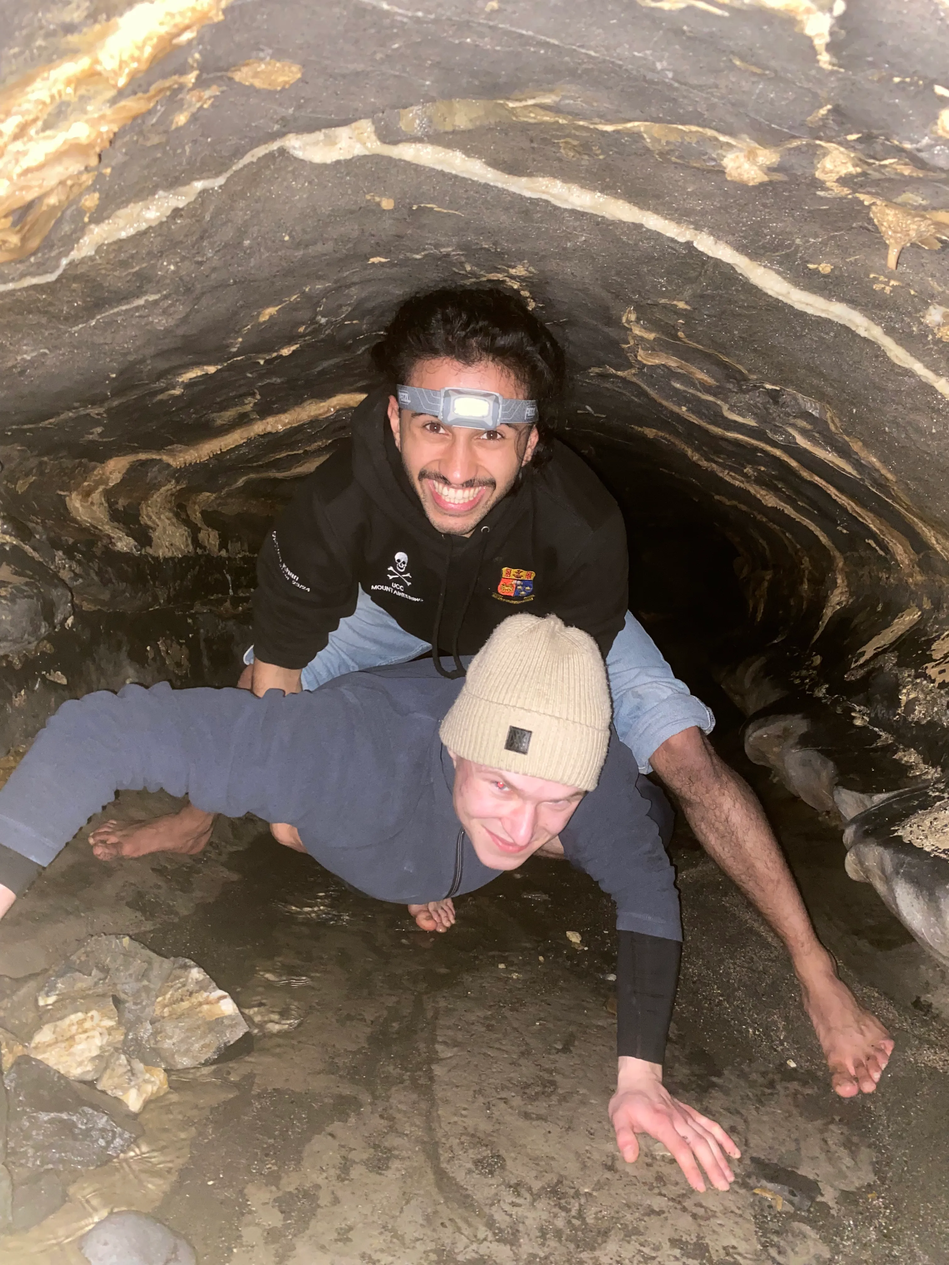 Exploring a narrow cave with friends and wearing a head torch